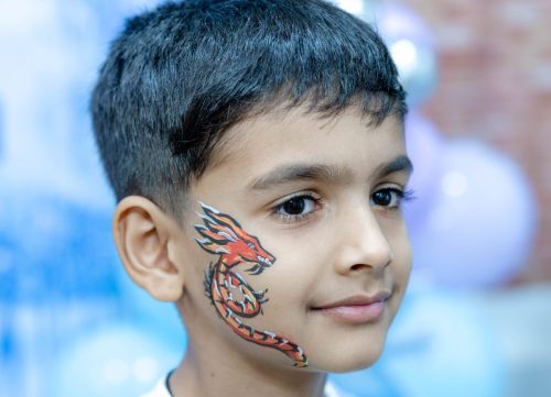 A boy showing his face paint painting