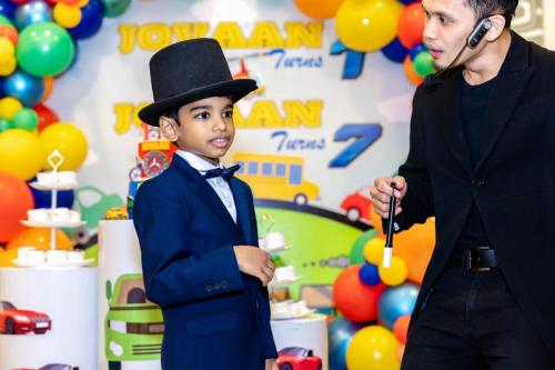 A boy celebrating his 7th birthday on his blue suite attire.