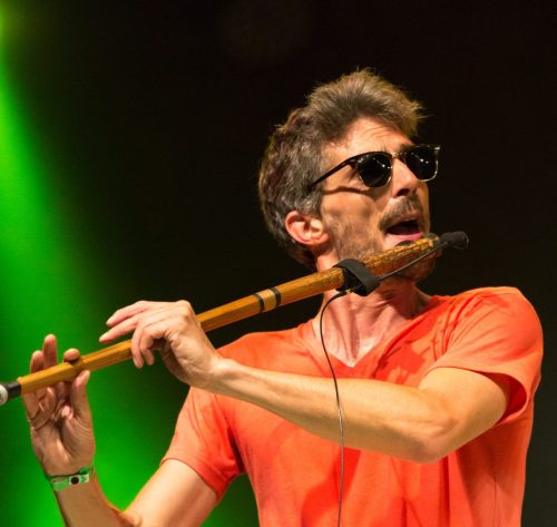 a man performing using his flute at music festival.